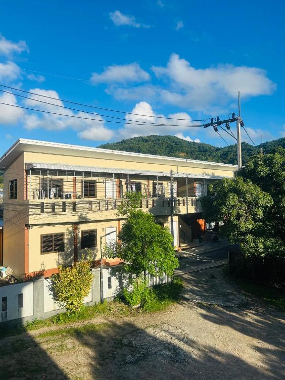 a large building with a balcony on the side of it at Fran Sim Da Guest House in Bang Tao Beach