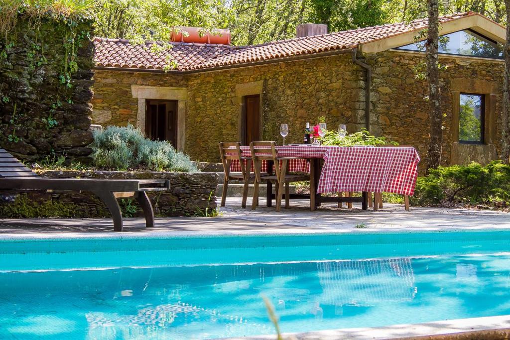 a house with a table and chairs next to a pool at Liiiving in Caminha | Oak Tree Chill House in Caminha