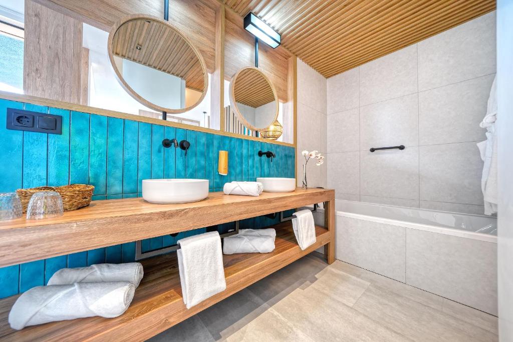 a bathroom with two sinks and a tub at HOVIMA Suites Costa Adeje in Adeje