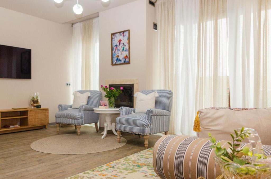 ポイアナ・ブラショフにあるSilver Mountain Retreat & SPAのリビングルーム(青い椅子、暖炉付)