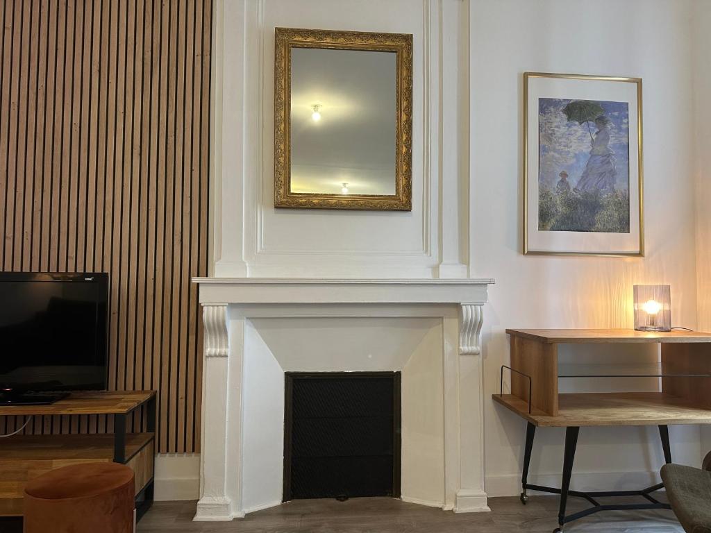 un salon avec une cheminée et un miroir dans l'établissement Cozy cocoon in Recouvrance, à Brest