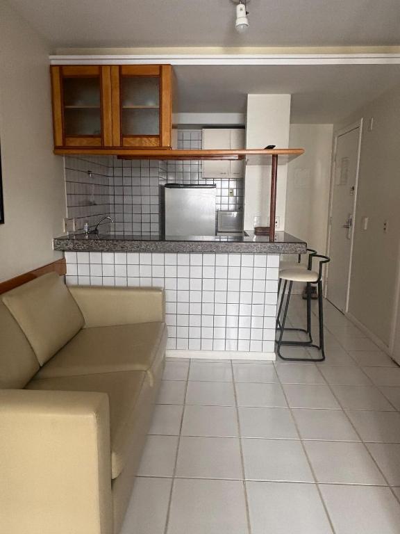 a living room with a couch and a kitchen at GuarapariResidence in Guarapari