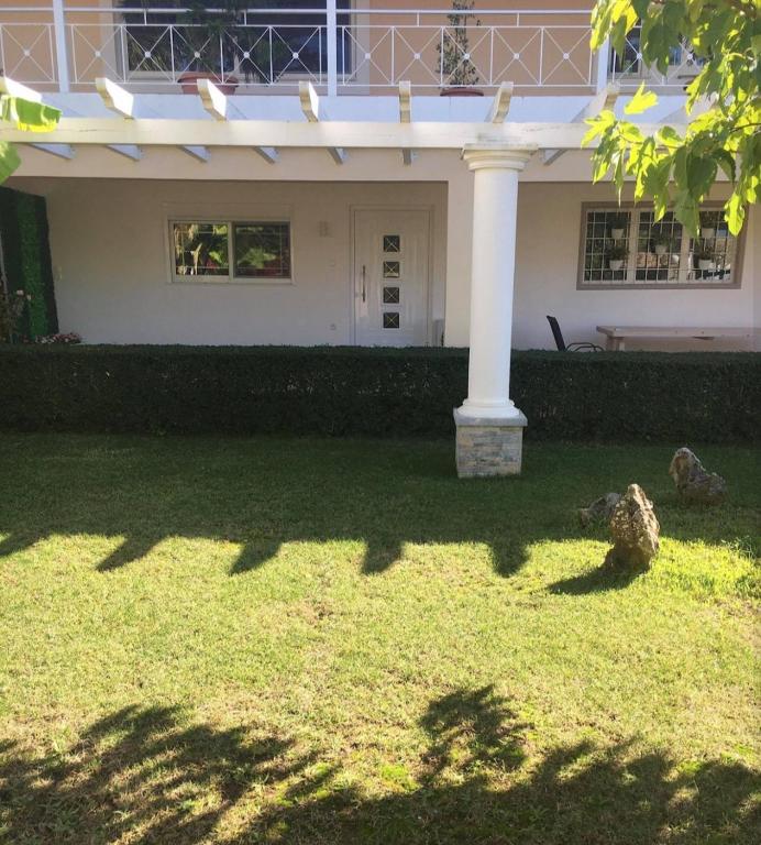 a house with a white column in the yard at Villa Morena in Mursi