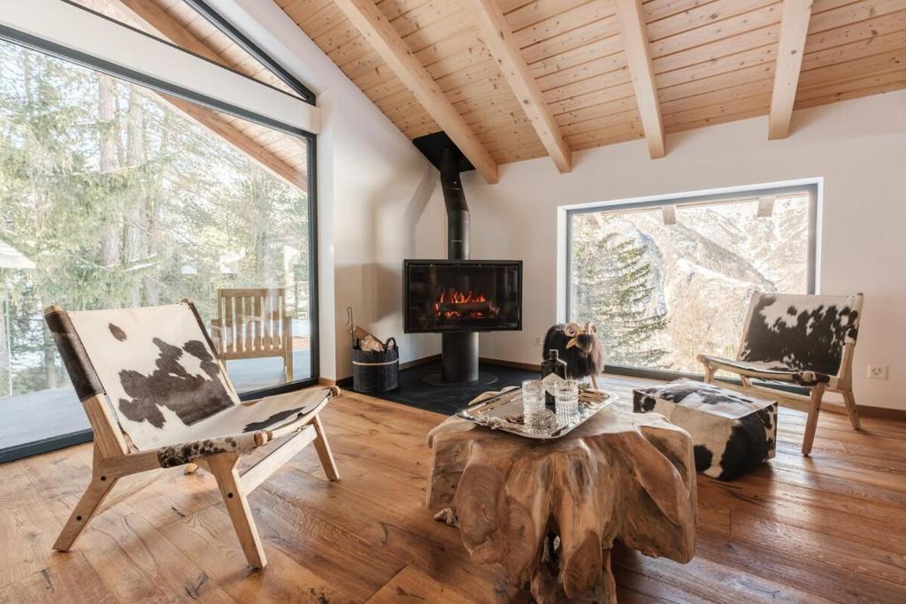 グレヘンにあるLuxury chalet with panoramic views, sauna, hot tub & cinemaのリビングルーム(木の切り株のコーヒーテーブル、暖炉付)