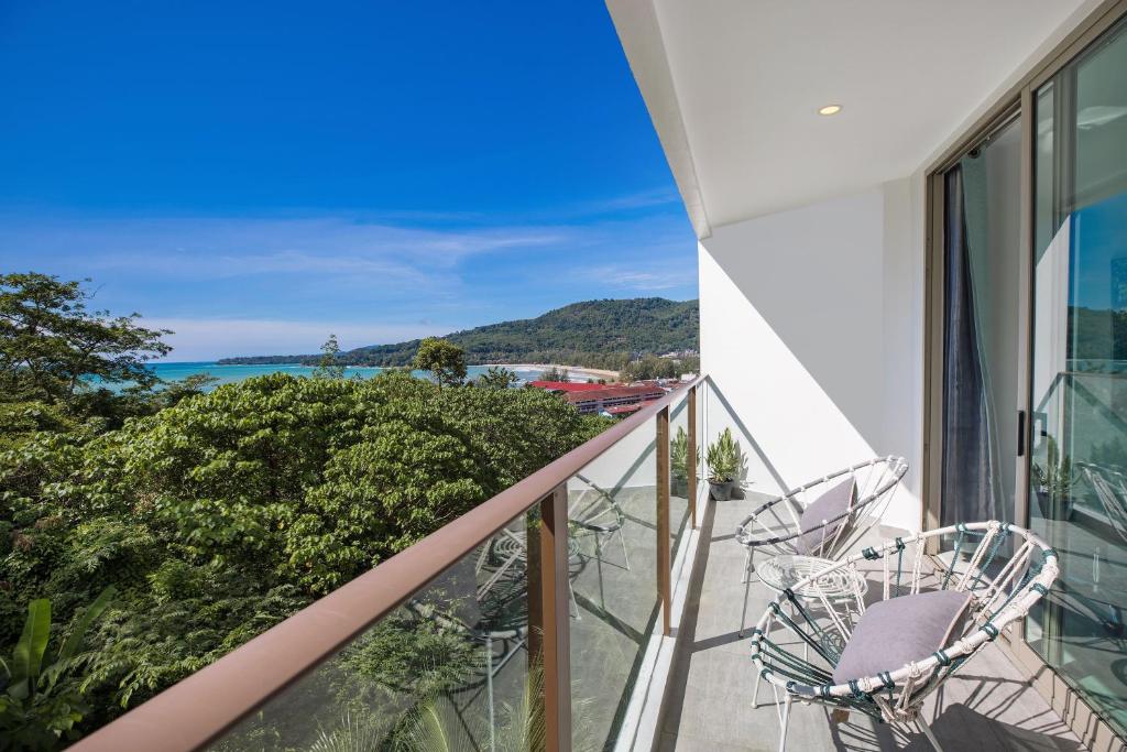 a balcony with chairs and a view of the ocean at Sea View Apartment A32 in Kamala Ocean Residence just 450m from Kamala Beach in Kamala Beach