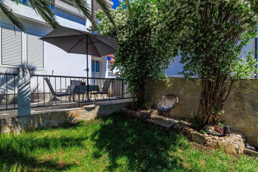 a balcony with an umbrella and a table and chairs at Apartment Andry 2 in Crikvenica