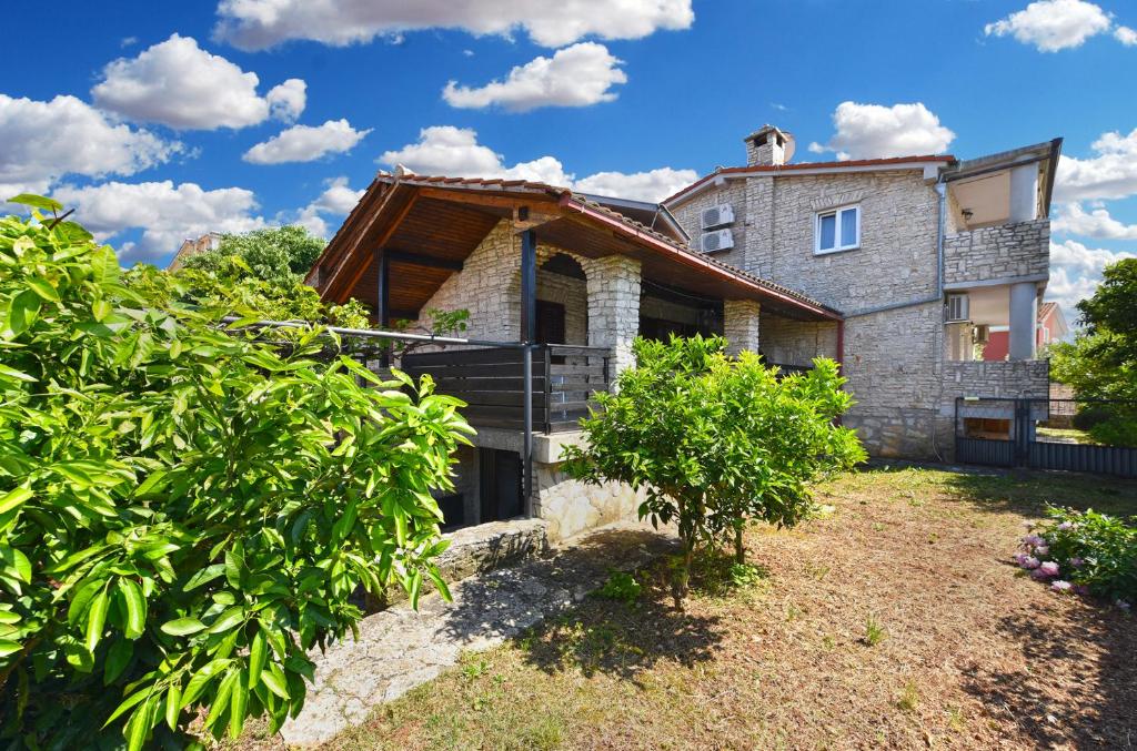a large stone house with a roof at Apartments Suzi 2381 in Peroj