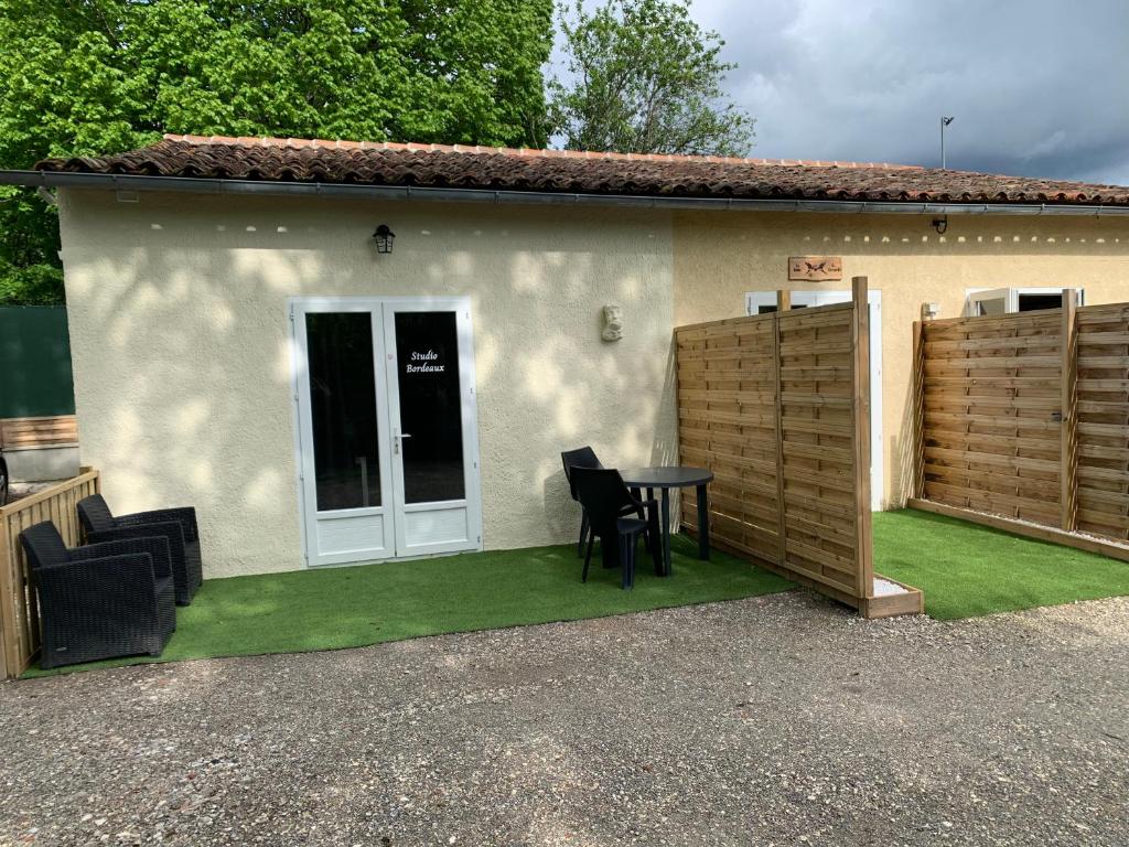 une maison avec une table et des chaises devant dans l'établissement Gîte NATURISTE Le Jardin Des Hirondelles, à Blanzaguet-Saint-Cybard-le-Peyrat