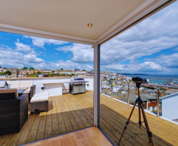 Una vista de un balcón con una cámara en un trípode. en Upper Anzac Sea View Retreat with Roof Terrace in Central Brixham, en Brixham
