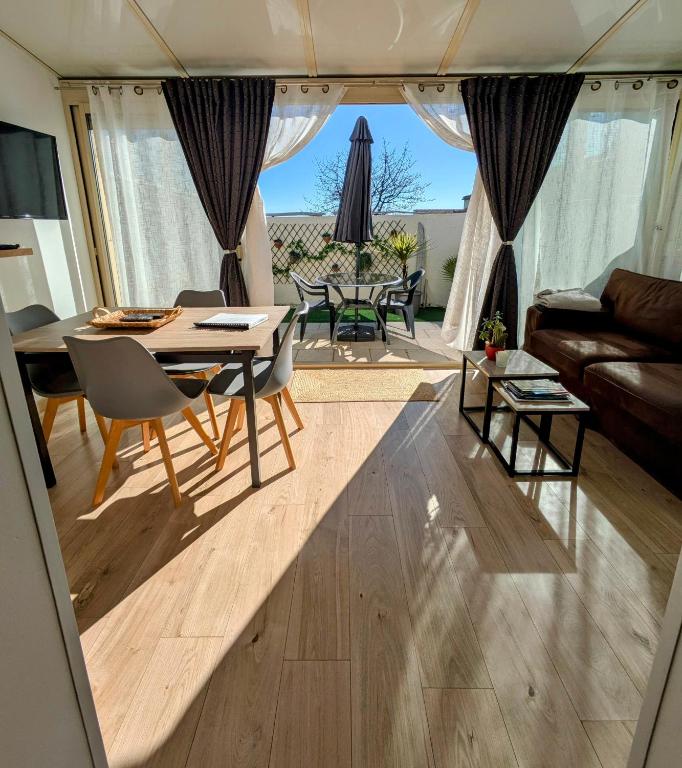 un salon avec une table, des chaises et un canapé dans l'établissement Escapade charentaise, à Aigrefeuille-dʼAunis