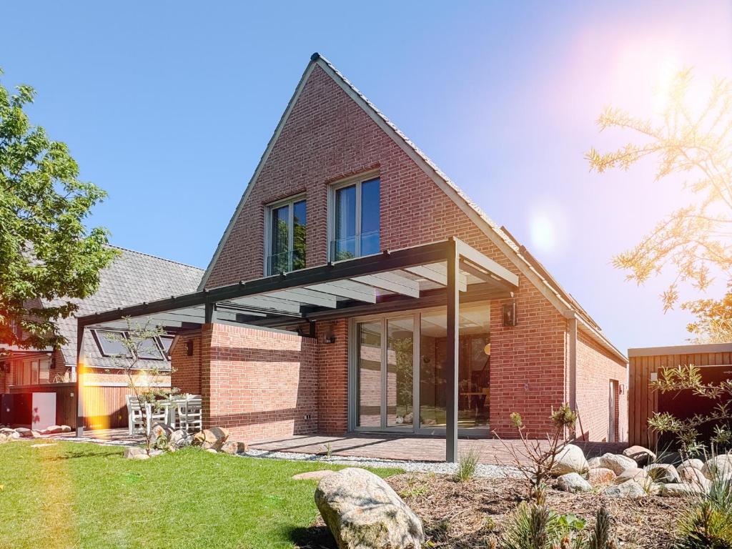 a brick house with a large glass extension at Strandhaus Südwesthörn in Norderney