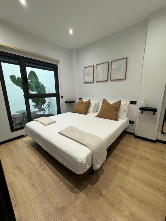 Una cama blanca grande en una habitación con una ventana grande. en Oasis Pavia 15, en Las Palmas de Gran Canaria