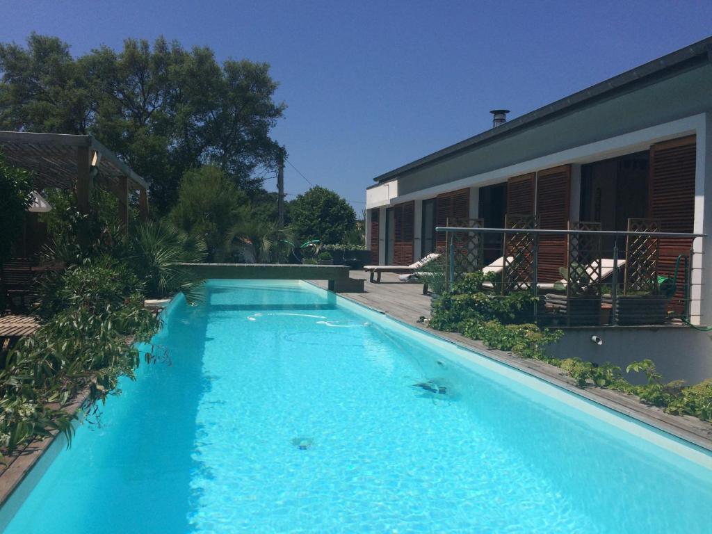 une grande piscine bleue à côté d'un immeuble dans l'établissement Villa La Pausa, à Capbreton