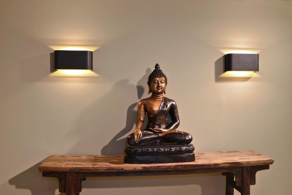 a statue sitting on a table with two lights at Monbijou Hotel in Berlin