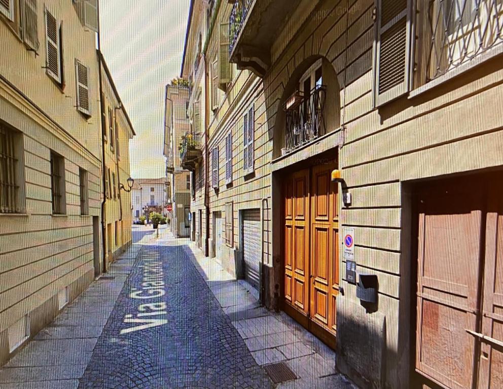 an empty alley with buildings and a street withcriptions on it at Home Sweet Home in Asti