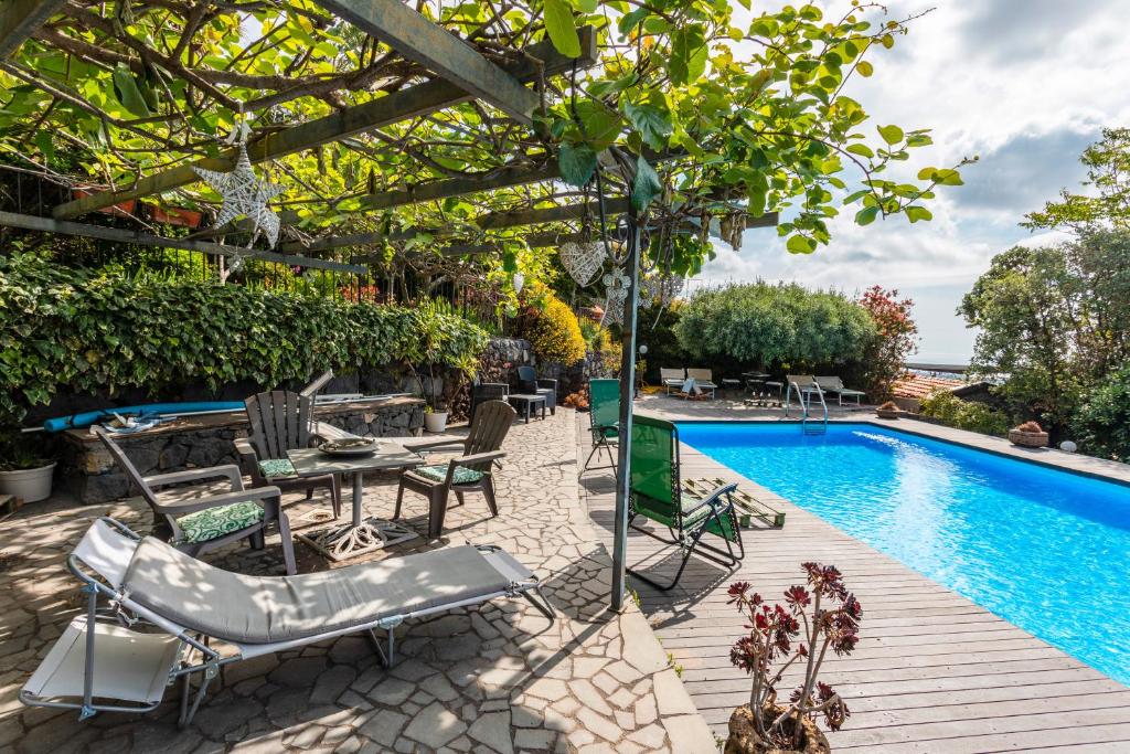 einen Pool mit Stühlen und einem Tisch neben einem Pool in der Unterkunft Queen Etna - Beautiful Pool in Viagrande