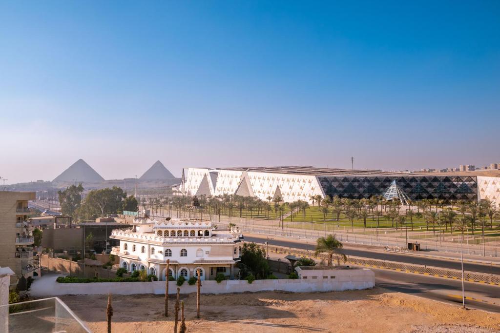 a view of a building with pyramids in the background at Arkan Egyptian Museum Hotel in Cairo