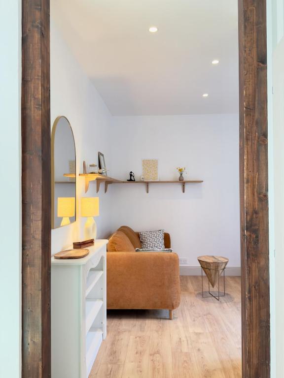 un salon avec un canapé et un miroir dans l'établissement Le patio - Une cours intérieur au coeur du vieux Dinan, à Dinan