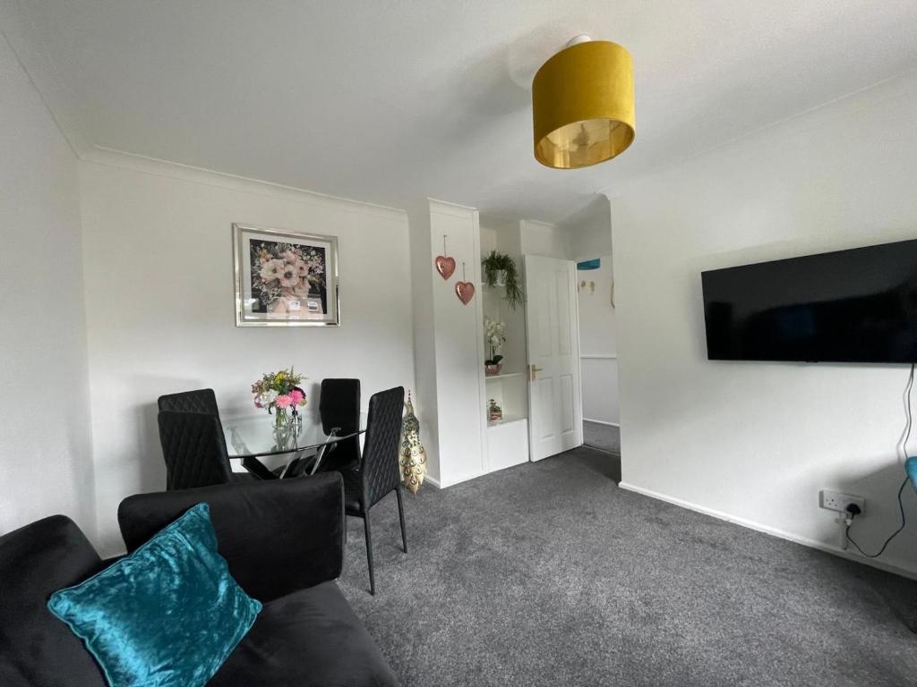 a living room with a couch and a table with chairs at Holly Copse in Stevenage
