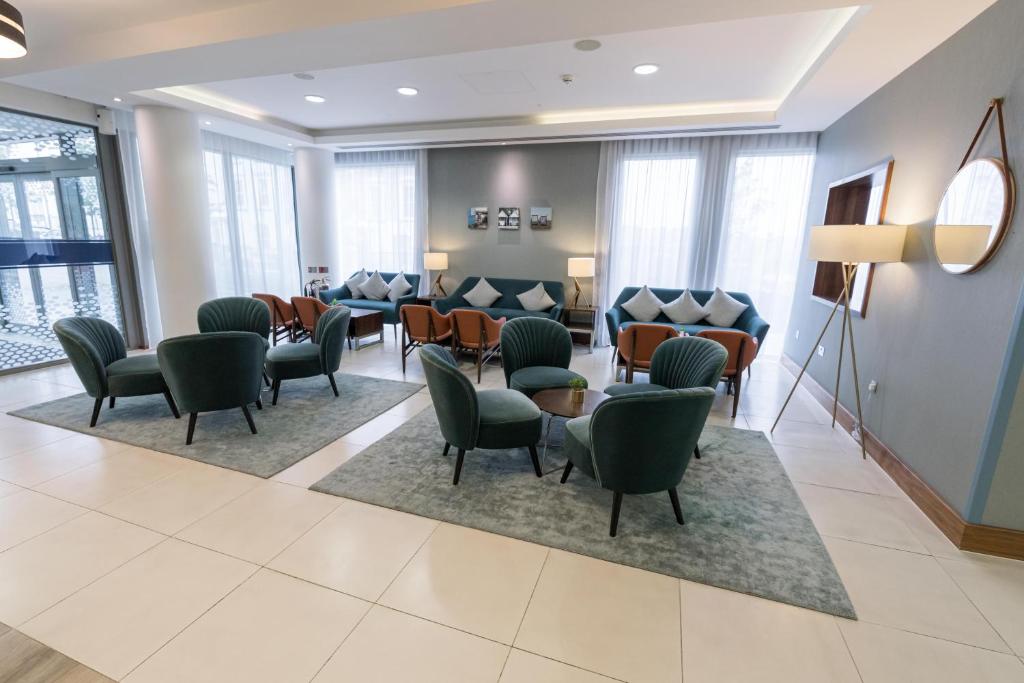 a waiting room at a hospital with chairs and tables at Hampton by Hilton Bournemouth in Bournemouth