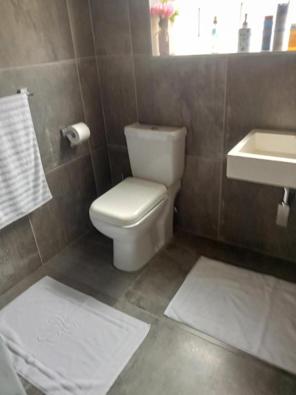 a bathroom with a toilet and a sink and towels at Mandoo guesthouse in Vosburg