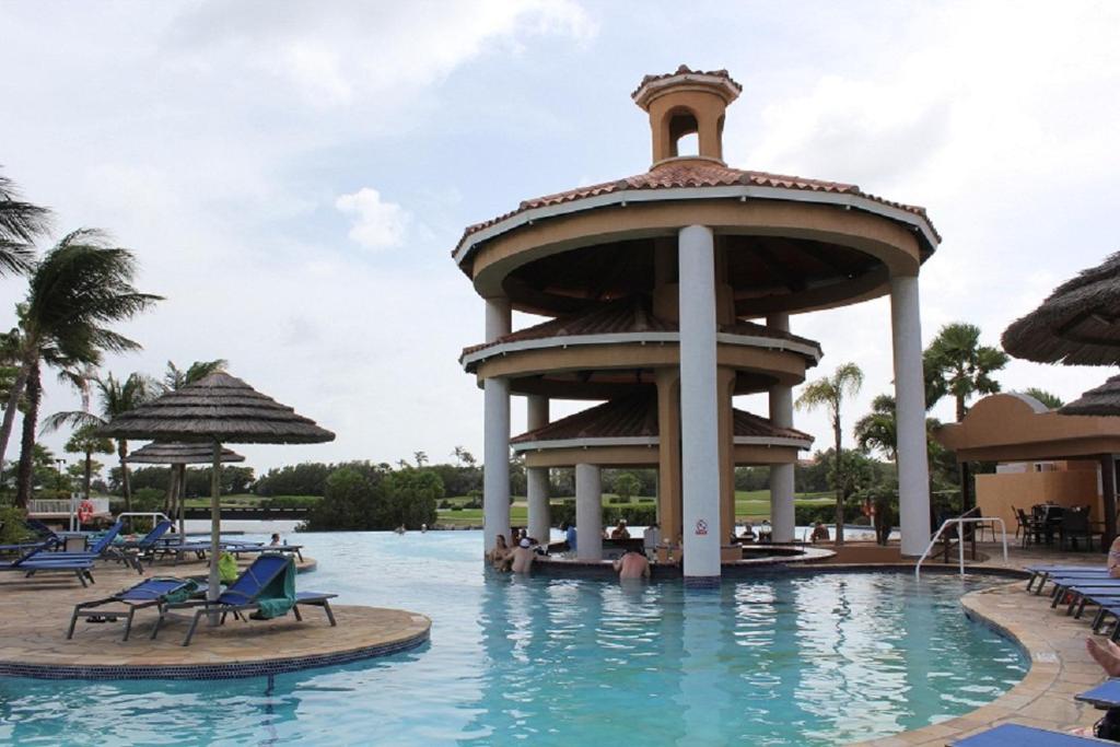 a pool at a resort with a tower in the water at Divi One Bedroom in Palm-Eagle Beach