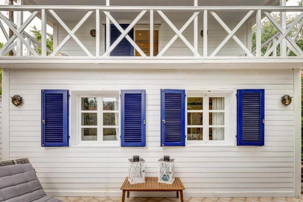 a white house with blue shutters and a table at Onde blu in Marina di Campo