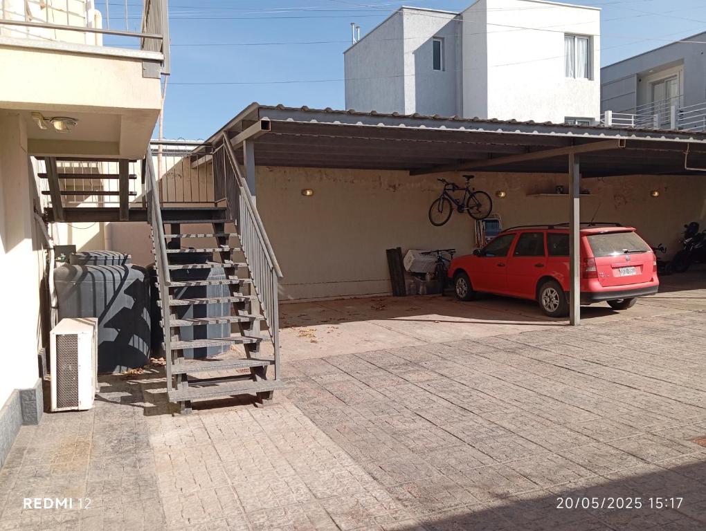 a garage with a car parked under a roof at Departamento frente al Arena Maipú Mendoza in Maipú