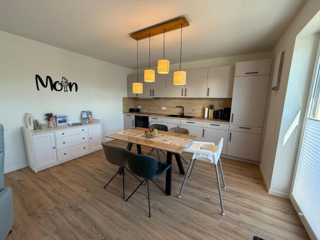 een keuken met een tafel en stoelen in een kamer bij Ferienwohnung Deichliebe in Butjadingen