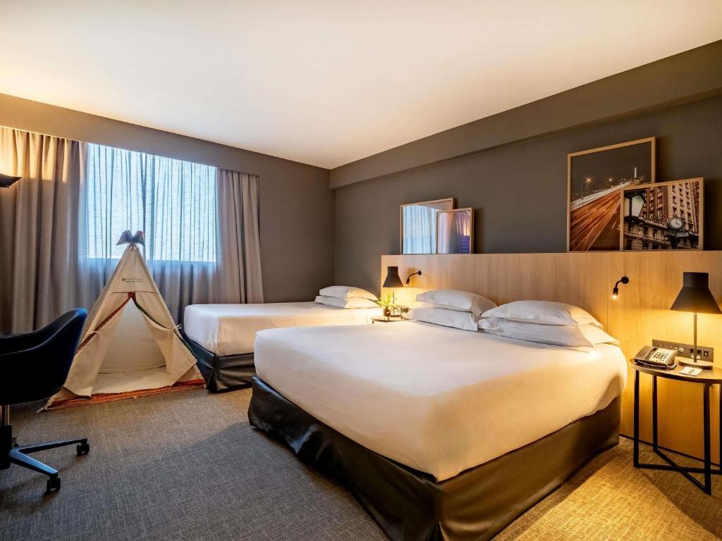 a hotel room with two beds and a tent at Pullman Sao Paulo Guarulhos Airport in Guarulhos