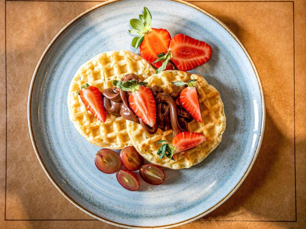 two waffles with fruit on a plate on a table at Pullman Sao Paulo Guarulhos Airport in Guarulhos