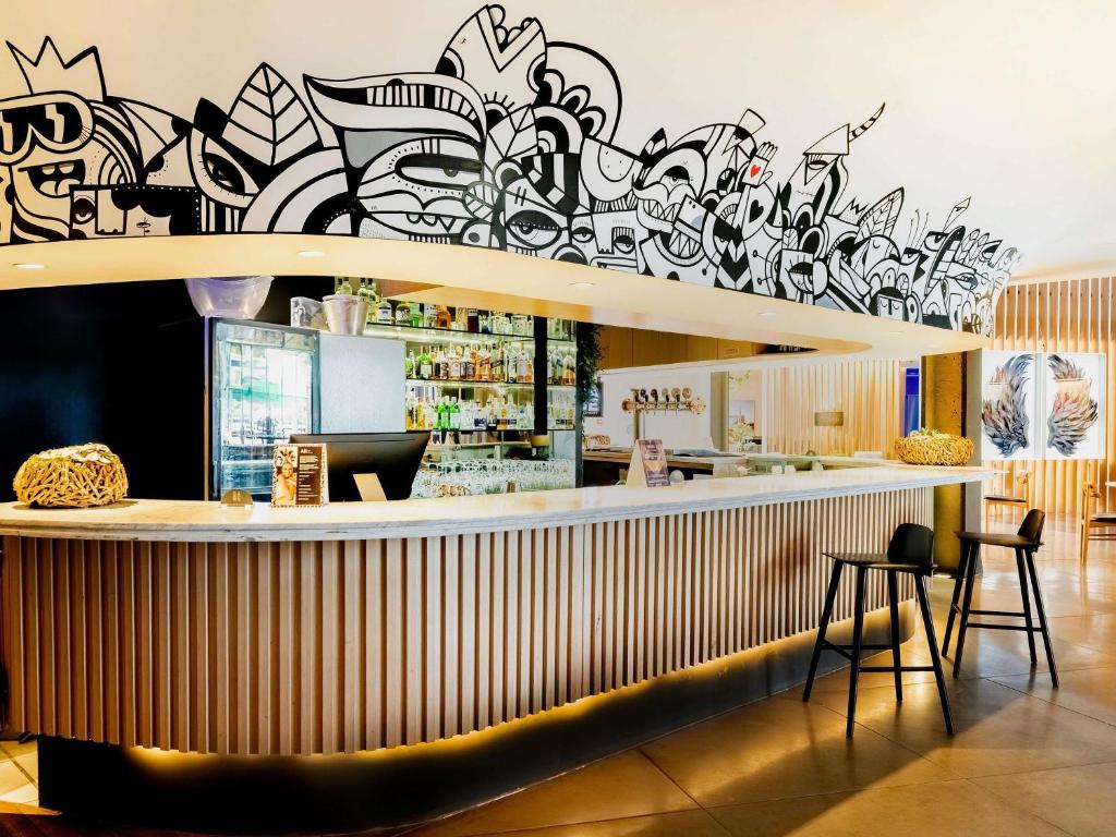 a bar with a wall covered in graffiti at Pullman Sao Paulo Guarulhos Airport in Guarulhos