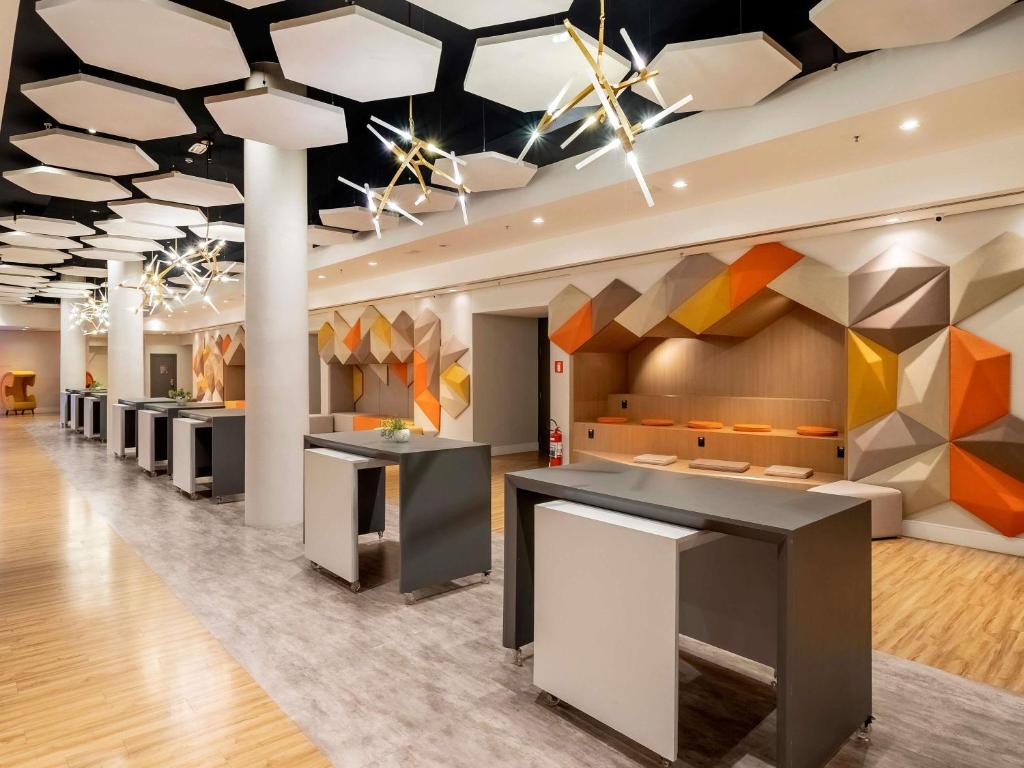 a lobby of a building with colorful ceilings at Pullman Sao Paulo Guarulhos Airport in Guarulhos