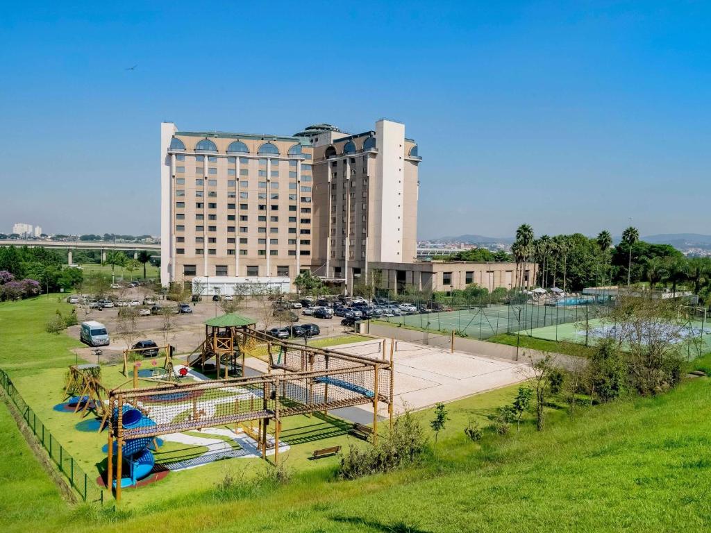 a large building with a playground in a park at Pullman Sao Paulo Guarulhos Airport in Guarulhos