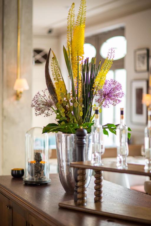 a vase filled with flowers on a table at Monbijou Hotel in Berlin