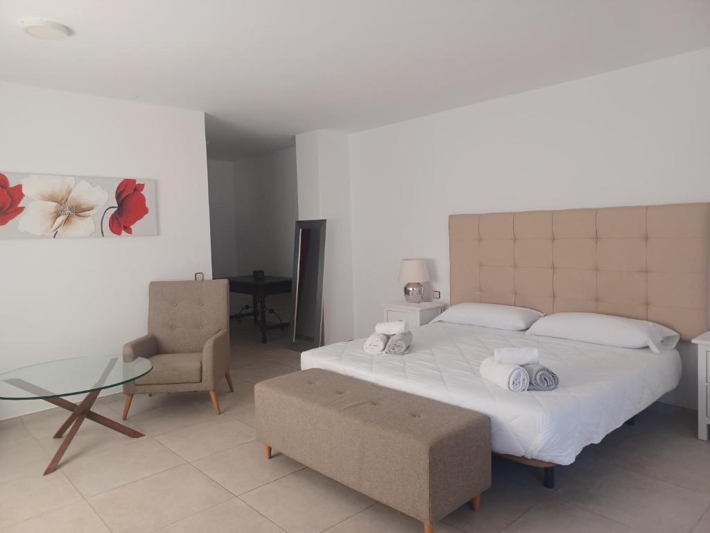 a bedroom with a large bed and a glass table at Villa Can Goldi con vistas al mar in Sant Josep