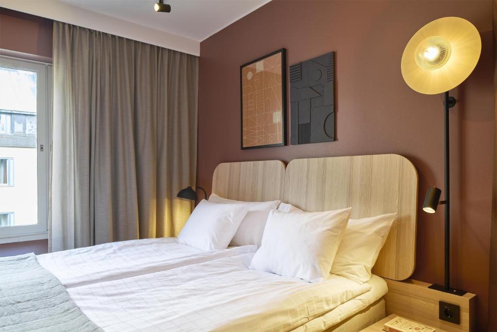 a bedroom with a large bed with white pillows at Scandic Malmen in Stockholm