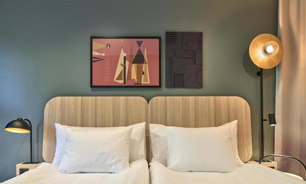 a bedroom with two beds and a painting on the wall at Scandic Malmen in Stockholm