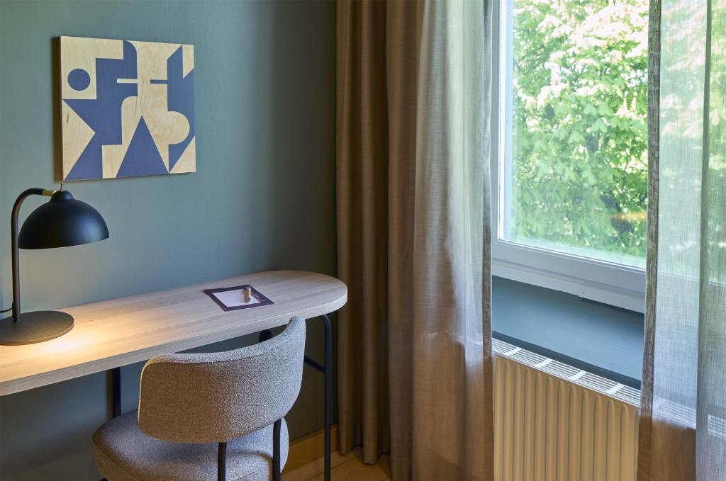 a desk with a chair next to a window at Scandic Malmen in Stockholm
