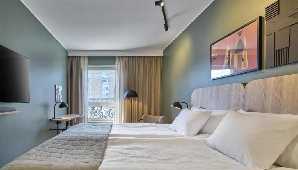 a bedroom with a large bed with white pillows at Scandic Malmen in Stockholm