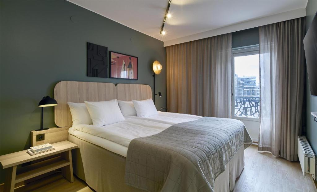 a bedroom with a large bed and a window at Scandic Malmen in Stockholm