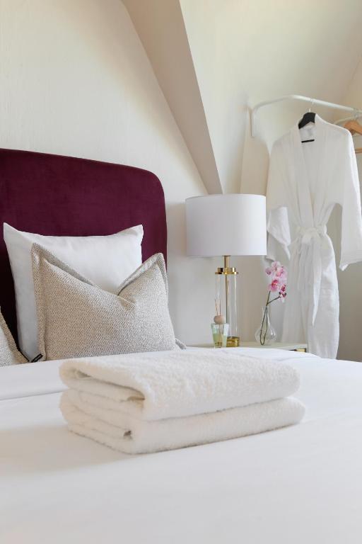 a white bed with a white towel on it at RESIDENCE WAVES Paris Orly Aéroport in Villeneuve-Saint-Georges
