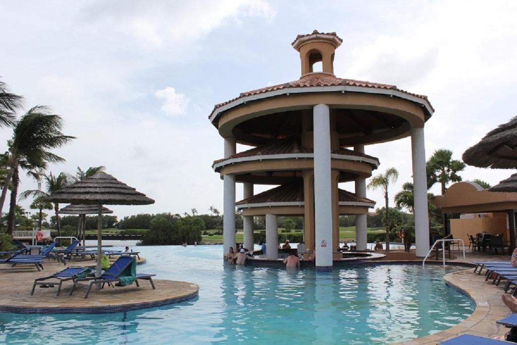 a pool at a resort with a tower in the water at Divi Studio in Palm-Eagle Beach
