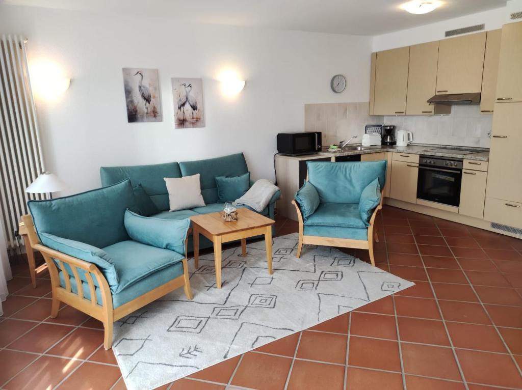 un soggiorno con un divano, sedie e un tavolo di Kranich - Ferienwohnung mit Terrasse a Dewichow