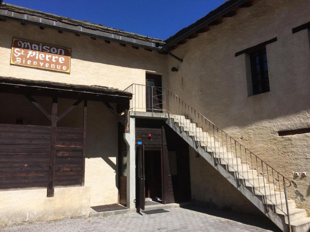 a building with a staircase and a sign on it at Maison St-Pierre in Bourg-Saint-Pierre