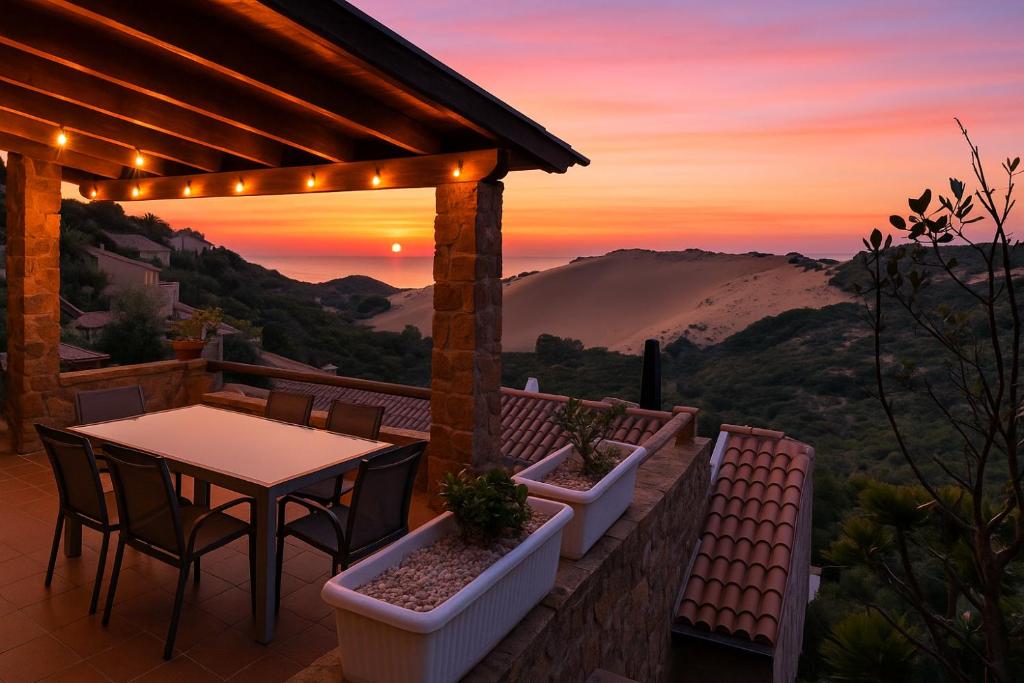 a patio with a table and chairs and a sunset at Casa vacanze Sardegna, Torre dei Corsari Costa Verde in Torre Dei Corsari