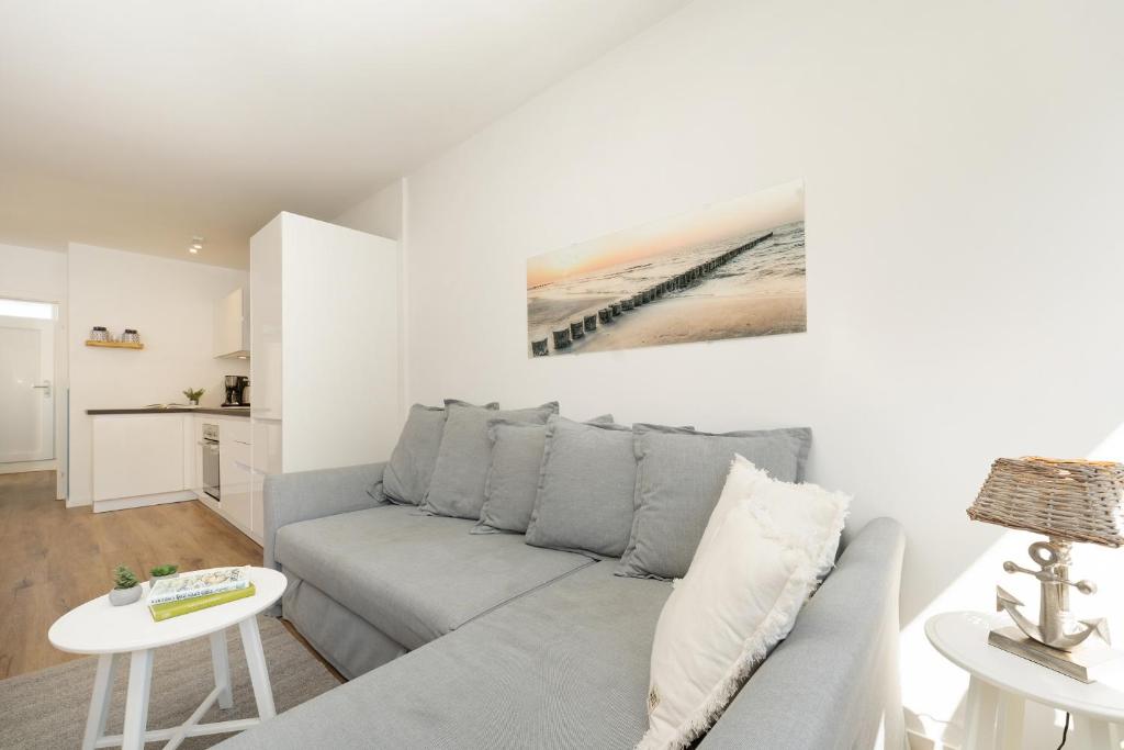 a living room with a couch and a table at Waldstraße 8 Blue Ocean in Kellenhusen
