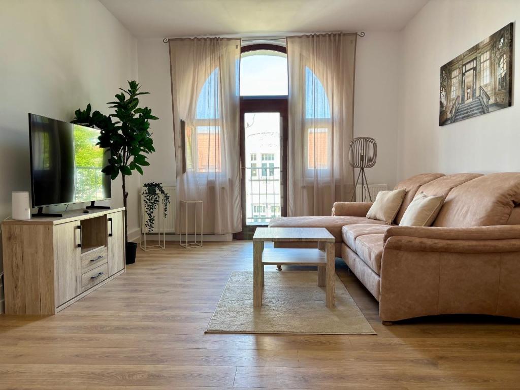 un salon avec un canapé et une télévision dans l'établissement YiPY Apartments am Landesmuseum Halle, à Halle-sur-Saale