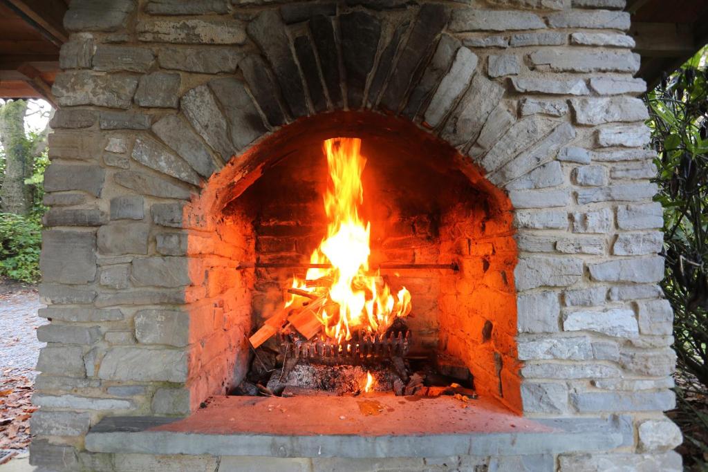 a brick oven with a fire in it at Parc-Le-Breos House in Penclawdd