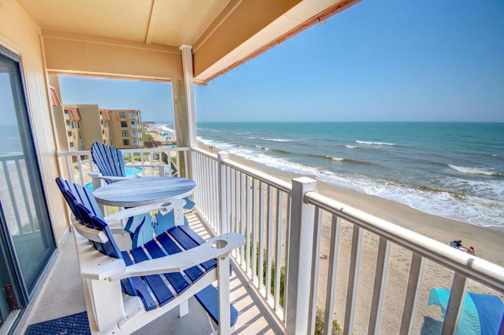 a balcony with two blue chairs and the ocean at Topsail Dunes 2308 in Chadwick Acres